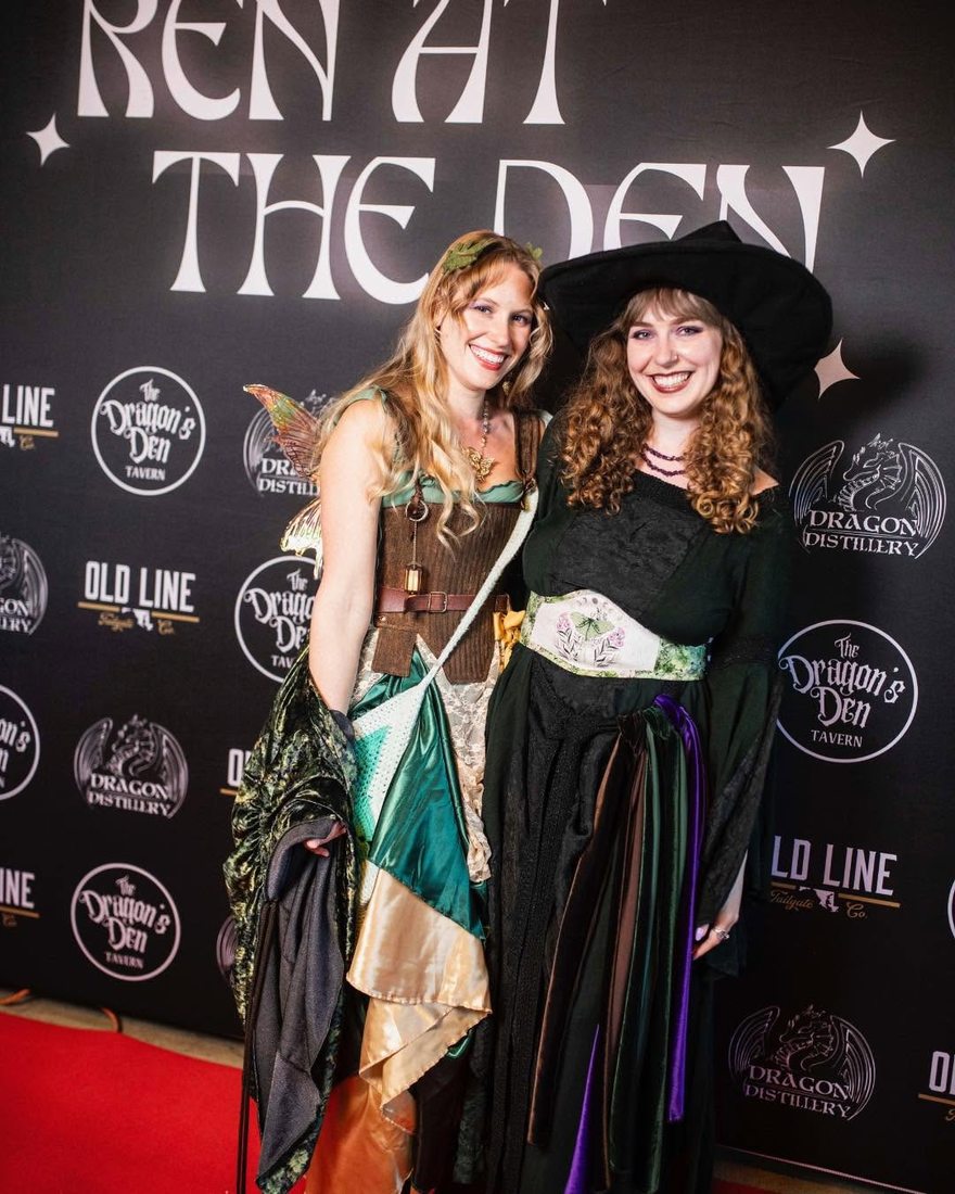 A fairy with wings and a witch in a wide-brimmed hat at the photo wall